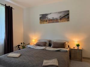 a bedroom with a bed with a painting on the wall at Lesný Dvor Retreat in Spišské Bystré