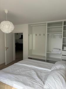 a bedroom with a large white bed and a chandelier at Prenočišče Henrik in Dolenjske Toplice