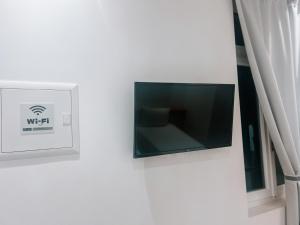 a flat screen tv on a wall next to a window at il Centro in Ios Chora