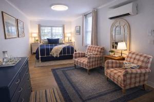 a bedroom with a bed and two chairs and a table at The Trellis House in Ogunquit