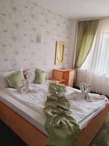 a bedroom with a bed with bows on it at Hotel Angely in Eforie Nord