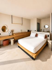 a bedroom with a large white bed and a bathroom at Tellion Villas-Member of My Villas Hospitality in Agios Nikitas