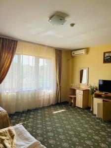 a hotel room with a bed and a window at Hotel Angely in Eforie Nord