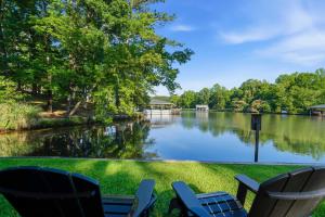 a view of a lake with two chairs and a lake at The Sinclair House Private Lake Retreat in Milledgeville