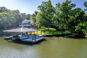 a large house with a dock in the water at The Sinclair House Private Lake Retreat in Milledgeville