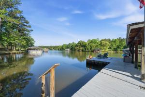 a dock with chairs on it next to a lake at The Sinclair House Private Lake Retreat in Milledgeville +86 photos