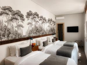 a hotel room with three beds and a tv at Riad Zyo in Rabat