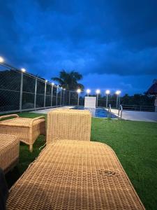 a patio with two wicker chairs and a fence at De Alcazar Calangute in Calangute +76 photos