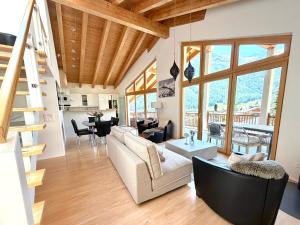 a living room with a couch and a table at Victoria's Home - luxurious penthouse in Saas-Fee