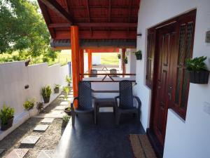 a patio with a table and chairs and a door at Aaliya Bay in Pottuvil