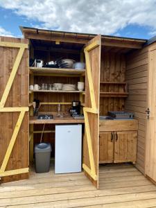 a kitchen with wooden cabinets and a white refrigerator at Tente Inca in Ambillou-Château