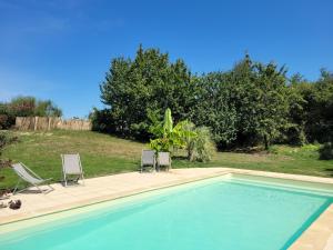 two chairs and a swimming pool in a yard at Tente Inca in Ambillou-Château +4 photos