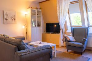 a living room with a couch and chairs and a tv at Bright Apartment in Haapsalu in Haapsalu