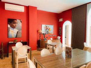 a dining room with red walls and white chairs at Riad Zyo in Rabat
