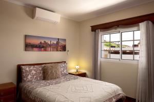 a bedroom with a bed and a window at Paradise House Calheta in Calheta +23 photos