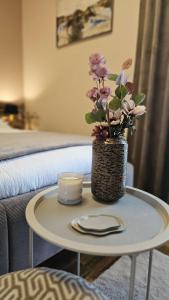 a table with a vase with flowers on it at Thea Golden Boutique in Wels