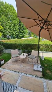 a patio with two chairs and an umbrella at Thea Golden Boutique in Wels