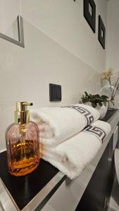 a bathroom counter with a bottle of perfume and a towel at Thea Golden Boutique in Wels +13 photos