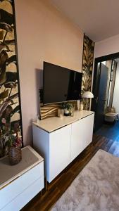 a living room with a flat screen tv on a white cabinet at Thea Golden Boutique in Wels