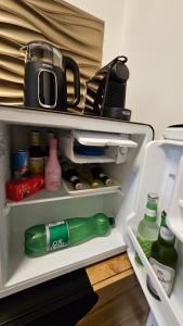 an open refrigerator with a green bottle in it at Thea Golden Boutique in Wels