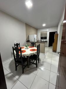 a table and chairs in a room with a kitchen at Lar doce lar in Barra do Garças +4 photos