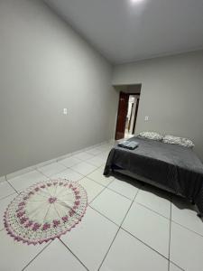 a bedroom with a bed and a flower rug on the floor at Lar doce lar in Barra do Garças