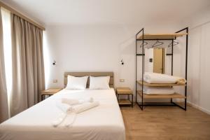 a bedroom with a large white bed and a mirror at Hotel Petro in Vlorë