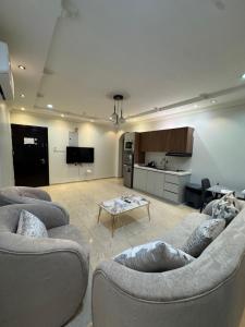 a living room with two couches and a table at أوركيد بالاس للشقق المخدومة in Riyadh