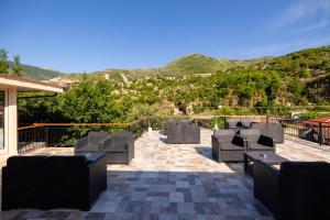a group of chairs on a patio with mountains in the background at Hotel Petro in Vlorë