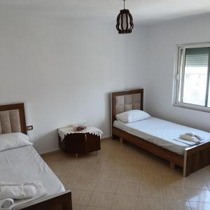 a bedroom with two beds and a window at Johnny Apartment Berat in Berat