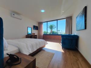 a bedroom with a large bed and a blue chair at Villa Mirasol Hotel in Tangier