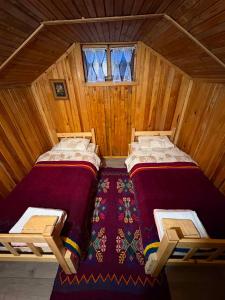 two beds in a wooden room with two windows at Katun Lanista-Kolibe Bogavac in Mojkovac +34 photos