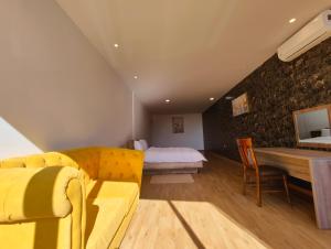 a living room with a yellow couch and a bed at Villa Mirasol Hotel in Tangier