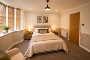 a bedroom with a large bed and two windows at Ai Stays Bentcliffe Suites in Moortown