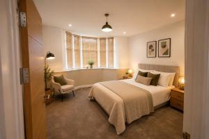 a bedroom with a bed and a chair and a window at Ai Stays Bentcliffe Suites in Moortown