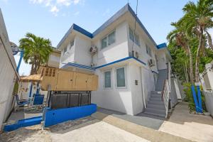 a white house with blue trim and palm trees at Downtown Studio at San Juan JL Guaynabo in San Juan +12 photos