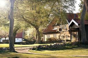a large house with trees in front of it at Kullagård Hotell in Mölle