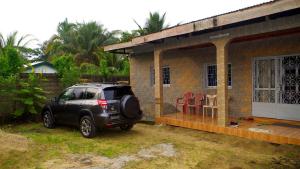 a black suv parked outside of a small house at Grand Studio à 200 m de la plage de Kribi Clim - Wi-Fi in Kribi