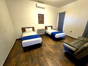 a hotel room with two beds and a couch at Abitare Mezcala Residencia in Isla de Mezcala