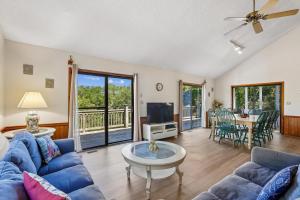 a living room with a blue couch and a tv at The Tree House in Duck