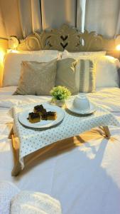 a table with a plate of food on a bed at Loft Desingn in Volta Redonda