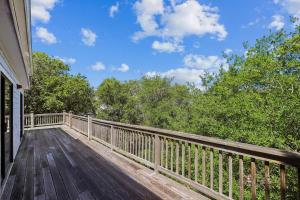 a wooden deck on a house with trees at The Tree House in Duck