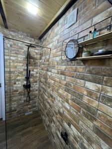 a bathroom with a brick wall and a shower at Cottage Merisi inn in Gundauri +56 photos