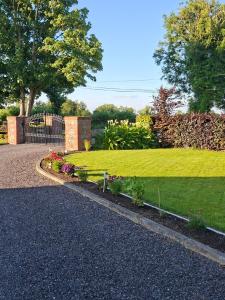 a garden with a gate and a lawn with flowers at White Quarry House in Navan +19 photos