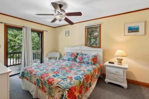 a bedroom with a bed and a ceiling fan at The Tree House in Duck