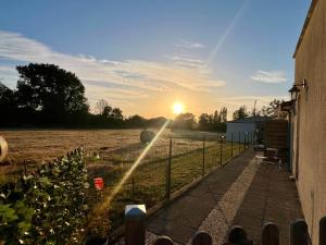 a sun setting over a field with a fence at Chez Laurie et Xavier studio 4 in Mignaloux-Beauvoir +1 photo