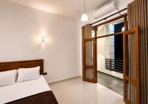 a bedroom with a bed and an open door at Araliya Hotel in Badulla