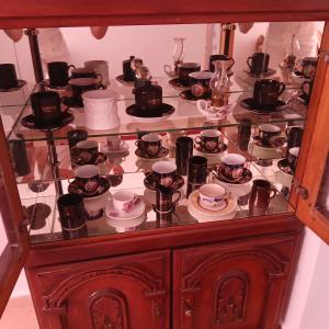 a glass display case filled with cups and teapots at Johnny Apartment Berat in Berat