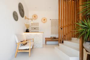 a living room with a staircase and a chair at Blue Waves Suites & Apartments - To Kyma in Drios +112 photos