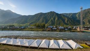 a group of white tents next to a river at GUREZ LUXURY Resort by GRITTI CASTLE in Wāmpor